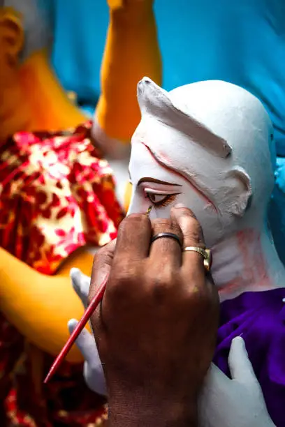 Kolkata; India - Asia; An artist gives final touches to idol of hindu Goddess Durga in workshop made of Plaster of Paris Clay at Kumortuli for upcomming Durgapuja festival 3