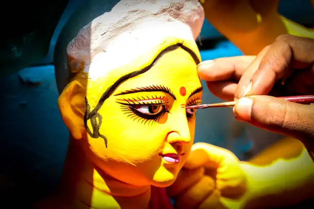 Kolkata; India - Asia; An artist gives final touches to idol of hindu Goddess Durga in workshop made of Plaster of Paris Clay at Kumortuli for upcomming Durgapuja festival 1