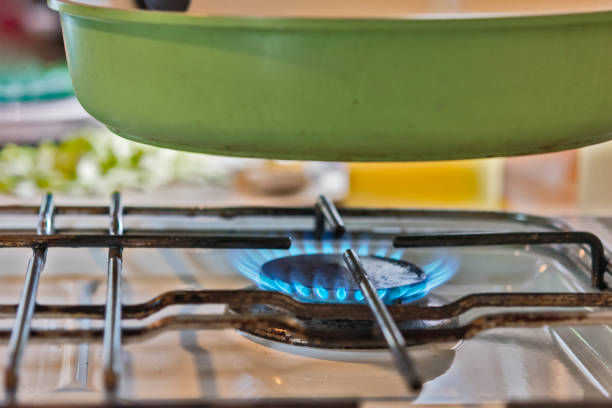He Prepares Dish in a Pan with Open Flames
