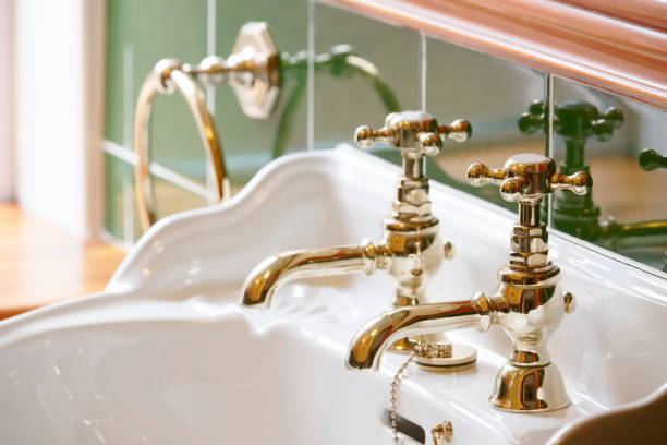 高級ホテルヴィンテージ真鍮金メッキピラータップは、洗面台でエンスイートバスルームで - gold plated ストックフォトと画像