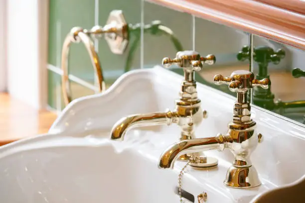Photo of Luxury hotel vintage brass gold plated pillar taps in ensuite bathroom at wash basin