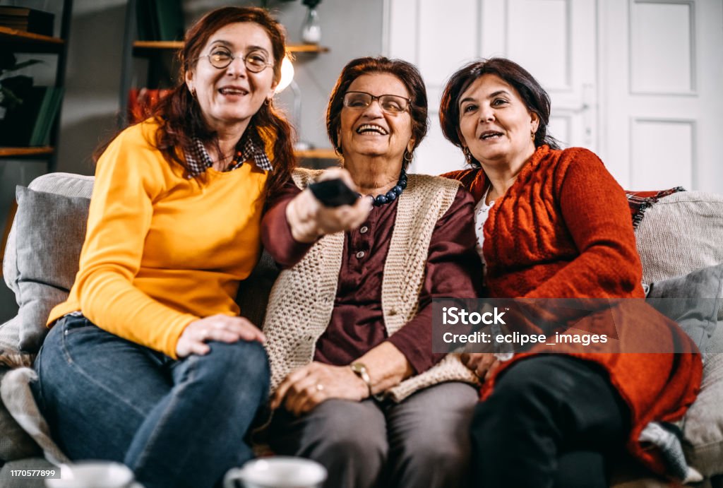 We are watching our favourite late night show Senior women watching late night show on tv Soccer Ball Stock Photo