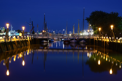 City harbour marina in Buesum, a German seaside resort and tourist destination at the north sea, blue hour night shot with many lights and copy space