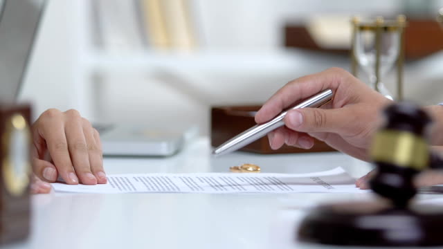 Lawyer explaining woman marriage contract statement before signing document
