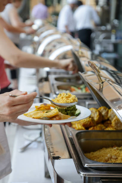 istock Woman taking food from a buffet line 1170590324