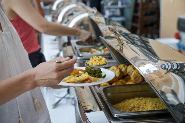 istock Woman taking food from a buffet line 1170590408