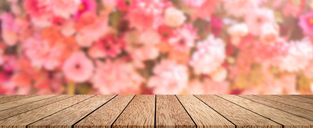 abstrakte verschwommene gruppe von frische blüten blumen panorama hintergrund mit holz deck tischplatte perspektive für show, fördern, anzeigen produkt auf display bild - flower market flower shop market flower stock-fotos und bilder