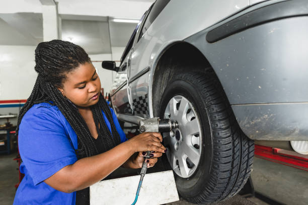 istock Mechanical woman screwing car wheels with compressed air tool 1170599838