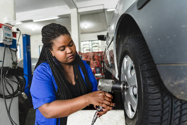 istock Mechanical woman screwing car wheels with compressed air tool 1170599840