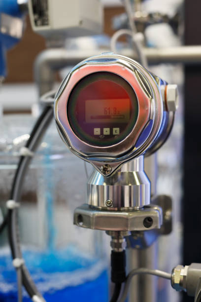 Industrial digital gauge measuring liquid flow at a chemical plant. Selective focus.