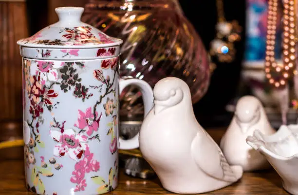 Photo of white porcelain doves with Japanese inspired cup on a vintage store shelf.