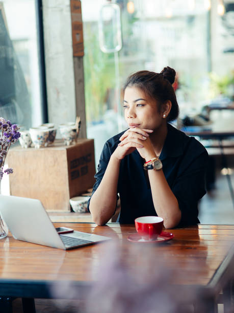 istock Asian woman working in cafe and looking out window. 1170617520