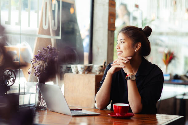 istock Asian woman working in cafe and looking out window. 1170617551