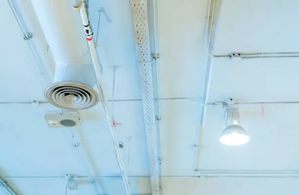 Photo of Air duct, automatic fire sprinkler safety system. Fire protection and detector. Fire sprinkler system. Building interior concept. Ceiling lamp light with opened light. Interior architecture concept.