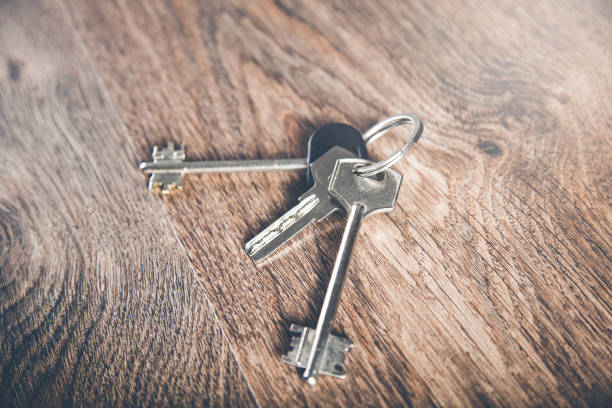 istock house key on the wooden desk background 1170617949