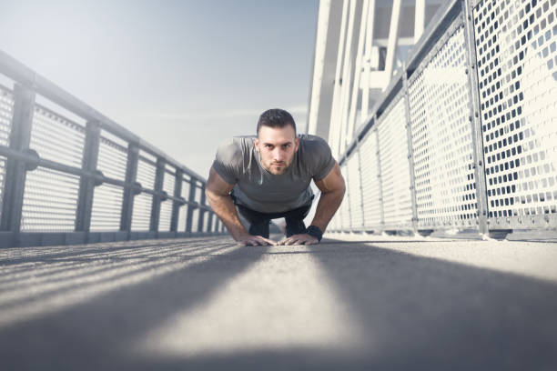 istock Sport. Young athletic man doing push ups on bridge 1170625563