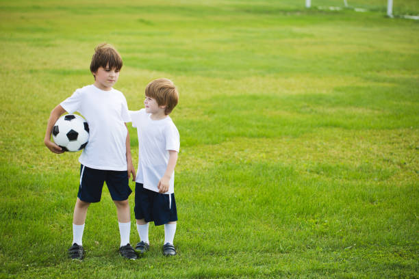 istock Two boys with a soccer ball on the grass. 1170626890