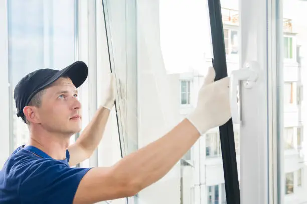 Photo of master puts a new double-glazed window in a plastic window