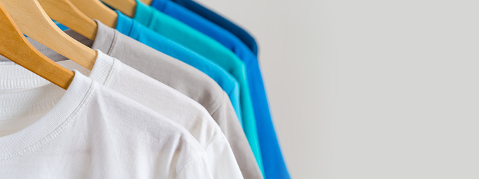 Close up of Colorful t-shirts on hangers, apparel background