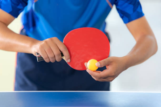 maschio che gioca a ping pong con racchetta e palla in una sala sportiva - table tennis table tennis racket racket sport ball foto e immagini stock