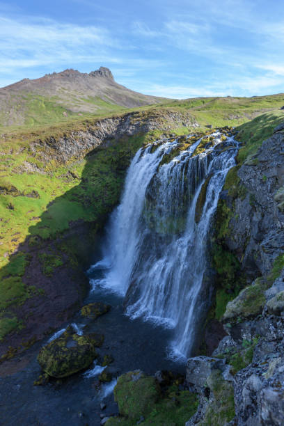 istock Iceland landscape with high waterfall among green hills. 1170638293