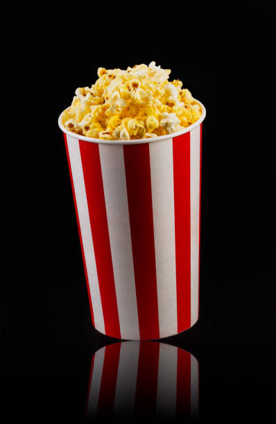 istock Paper striped bucket with popcorn isolated on black background 1170640281