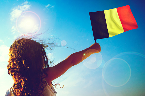 Little girl waving Belgian Flag on sunny beautiful day