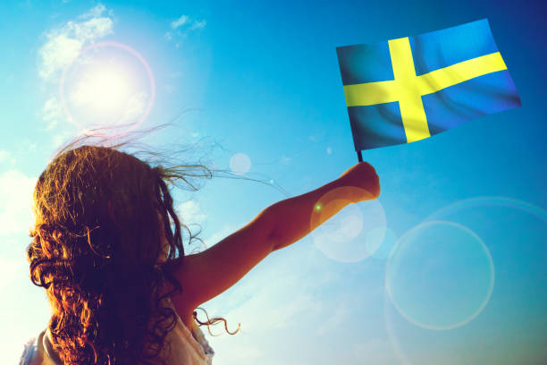 Little girl waving Swedish Flag on sunny beautiful day