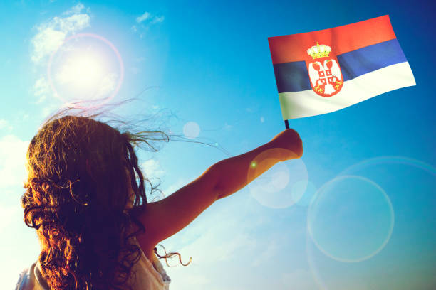 Little girl waving Serbian Flag on sunny beautiful day