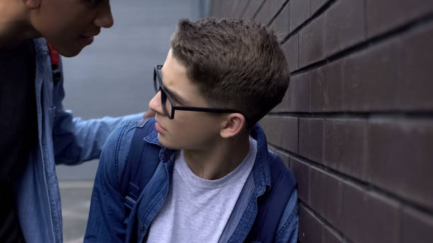 istock African-american student threatening classmate, pushing to wall, school bullying 1170641786