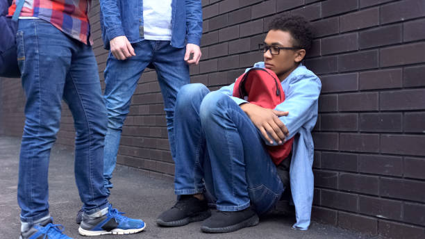 istock Black boy leaning against wall, scared of bully students, racial discrimination 1170641916
