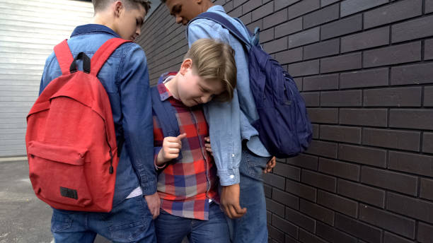 istock Senior students stopping boy in backyard, demonstrating authority, bullying 1170641958