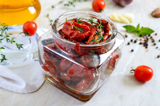 sun-dried tomatoes with herbs, garlic in olive oil in a glass jar on a light background. - restaurant pasta italian culture dinner imagens e fotografias de stock