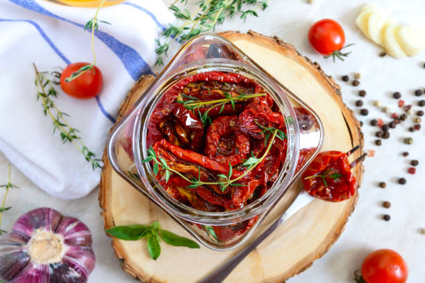 sun-dried tomatoes with herbs, garlic in olive oil in a glass jar on a light background. top view, flat lay - restaurant pasta italian culture dinner imagens e fotografias de stock