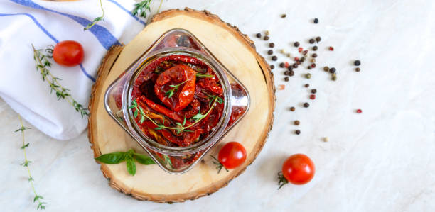 sun-dried tomatoes with herbs, garlic in olive oil in a glass jar on a light background. top view, flat lay - restaurant pasta italian culture dinner imagens e fotografias de stock