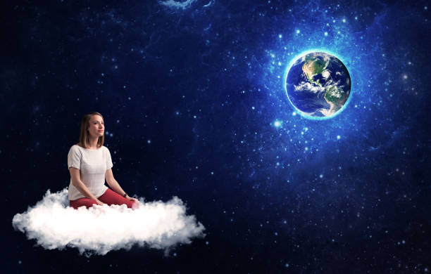istock Woman sitting on cloud looking at planet earth 1170651260
