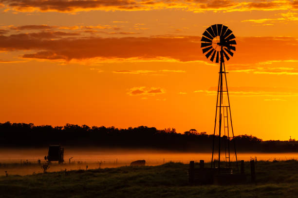 istock Silhouette windmill in a field with vivid rural sunrise 1170651623