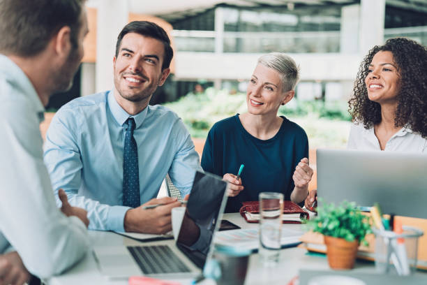 istock Multi-ethnic group of business persons sitting around a table and talking 1170654265