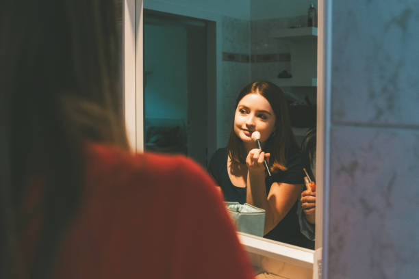 istock young woman putting up make up in front of mirror 1170657936