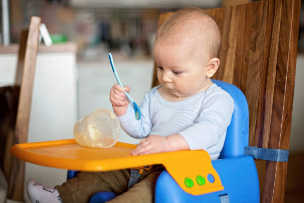 istock Little baby boy, eating mashed food for the first time 1170658013