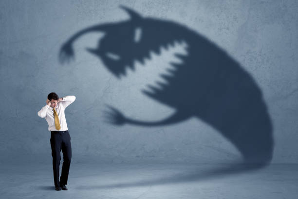 Business man afraid of his own shadow monster concept Business man afraid of his own shadow monster concept on grungy background evil stock pictures, royalty-free photos & images