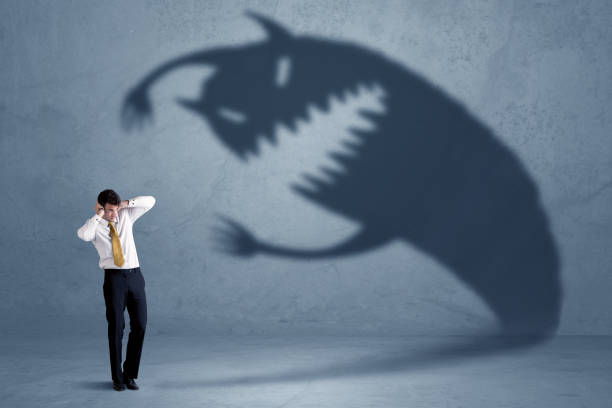 Business man afraid of his own shadow monster concept Business man afraid of his own shadow monster concept on grungy background evil corporation stock pictures, royalty-free photos & images