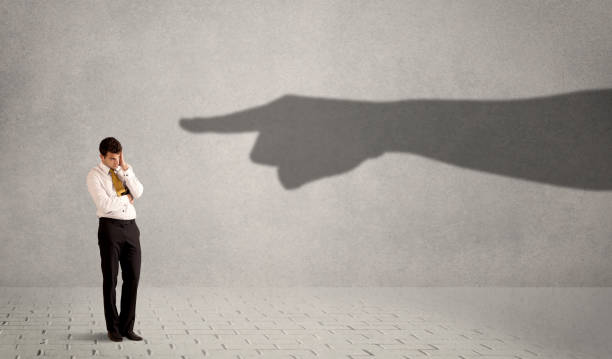 istock Business person looking at huge shadow hand pointing at him concept 1170662433