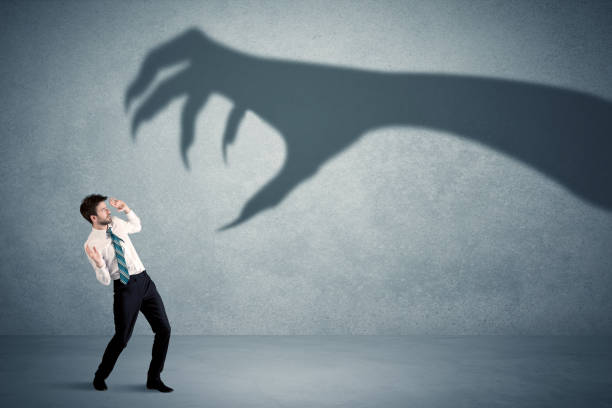 istock Business person afraid of a big monster claw shadow concept 1170664146
