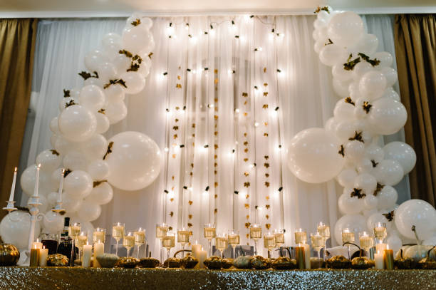 istock Table setting for wedding. Decorated arch for wedding ceremony. White balloons, candles, autumn leaves and small pumpkins. Autumn location and Halloween decor. 1170667782