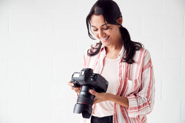 istock Female Photographer With Camera On Photo Shoot Against White Studio Backdrop 1170667787