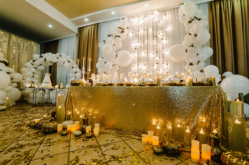 Ajuste de mesa para la boda. Arco decorado para la ceremonia de boda. Globos blancos, velas, hojas de otoño y pequeñas calabazas. Ubicación de otoño y decoración de Halloween. photo