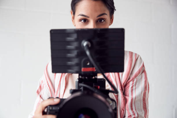 istock Female Videographer With Video Camera Filming Movie In White Studio 1170667840