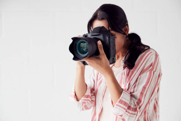 istock Female Photographer With Camera On Photo Shoot Against White Studio Backdrop 1170667845