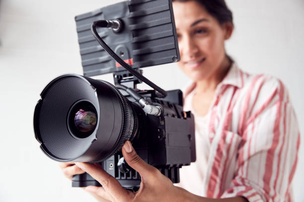 istock Female Videographer With Video Camera Filming Movie In White Studio 1170667909
